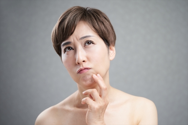 悩みながら上を見上げる女性